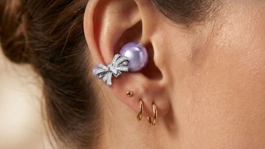 ViSound Adorn clip-on earbud with a bow charm, worn next to gold hoop earrings