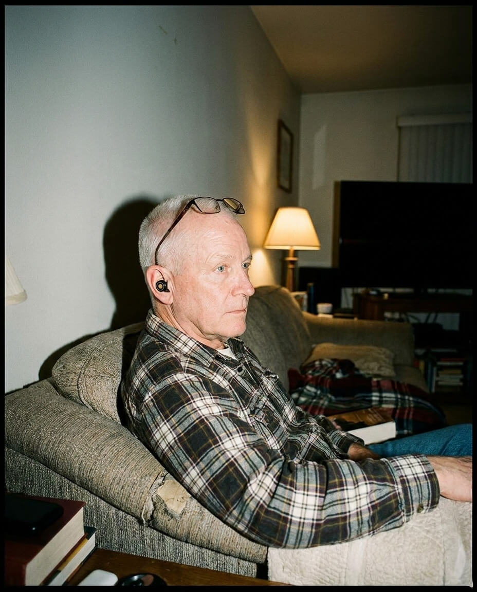 A person in profile with their eyes closed, wearing a single, flesh-toned earbud.