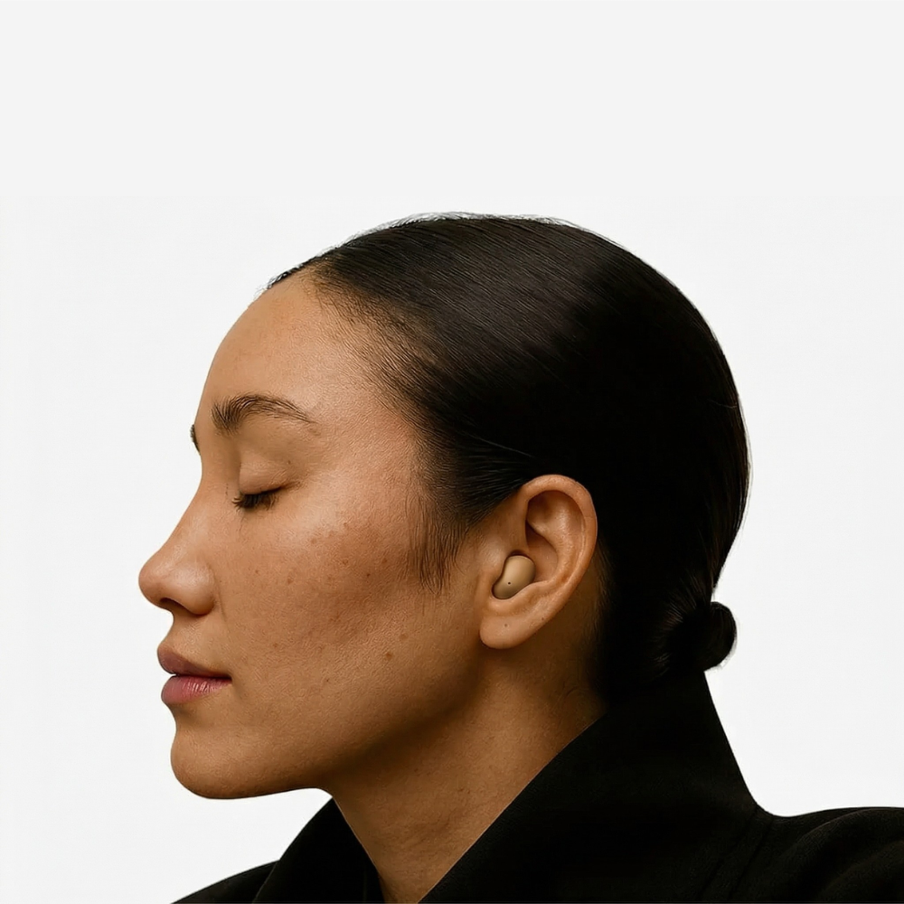 A person in profile with their eyes closed, wearing a single, flesh-toned earbud.